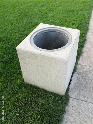 garbage container on green grass. a rectangular trash can in the park. ecology, cleanliness