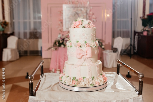 Three-tier wedding cake decorated with creamy roses