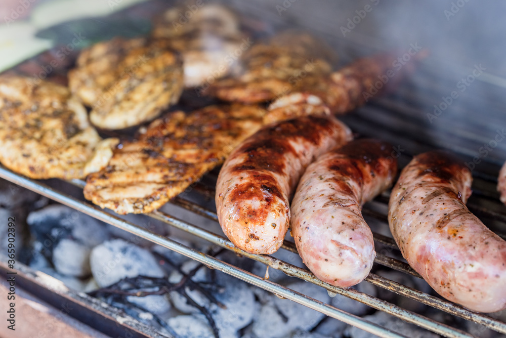 Grilling sausages and meat on a barbecue grill.