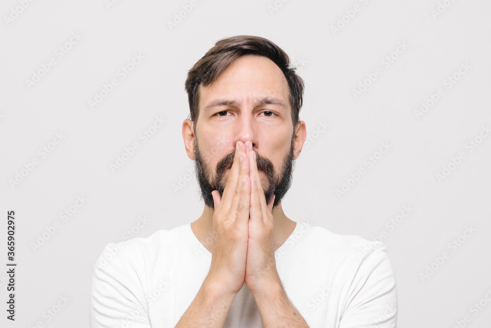 close portrait. young man covers his mouth with his palms close portrait. young man covers his mouth with his palms