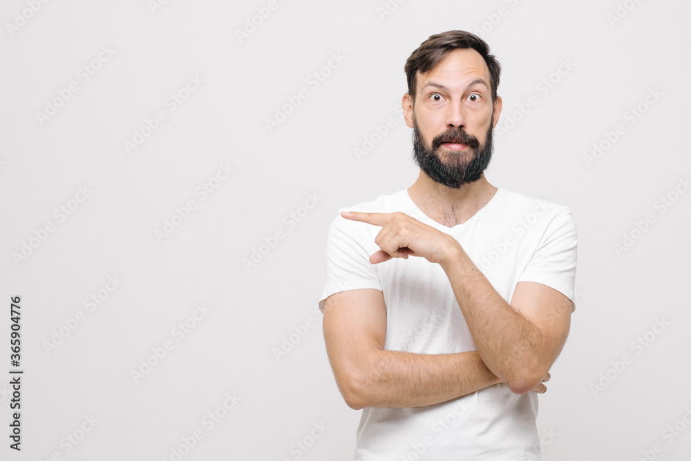 excited young man pointing with fingers and looking away on white background excited young man pointing with fingers and looking away on white background