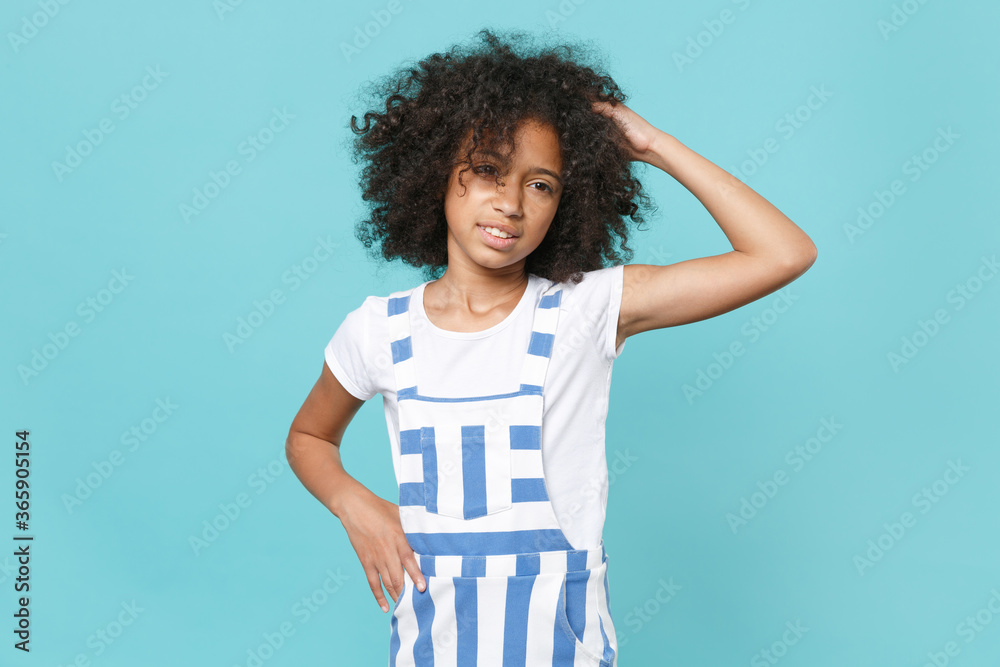 Preoccupied little african american kid girl 12-13 years old in striped clothes isolated on blue wall background studio portrait. Childhood lifestyle concept. Mock up copy space. Put hand on head. Preoccupied little african american kid girl 12-13 years old in striped clothes isolated on blue wall background studio portrait. Childhood lifestyle concept. Mock up copy space. Put hand on head.