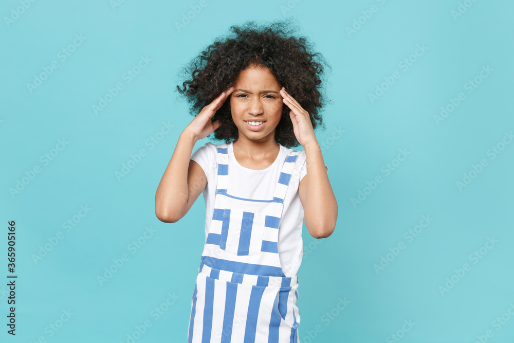 Dissatisfied worried little african american kid girl 12-13 years old in striped clothes isolated on blue background studio portrait. Childhood lifestyle concept. Mock up copy space. Put hand on head. Dissatisfied worried little african american kid girl 12-13 years old in striped clothes isolated on blue background studio portrait. Childhood lifestyle concept. Mock up copy space. Put hand on head.