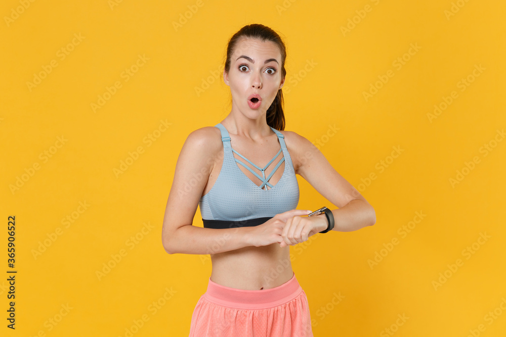 Shocked young fitness sporty woman girl in sportswear working out isolated on yellow background studio. Workout sport motivation lifestyle concept. Mock up copy space. Wearing smart watch on hand. Shocked young fitness sporty woman girl in sportswear working out isolated on yellow background studio. Workout sport motivation lifestyle concept. Mock up copy space. Wearing smart watch on hand.