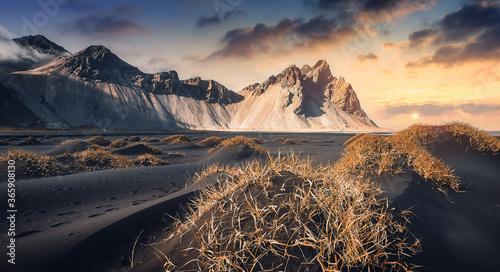 Impressively beautiful nature of Iceland. Fantastic colorful sky over the Vestrahorn mountaine on Stokksnes cape in Iceland during sunset. Wonderful Picturesque Icelandic landscape.