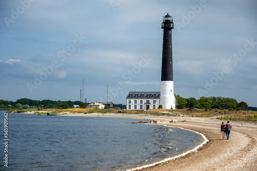 Large black&white lighthouse on the island by the sea shore