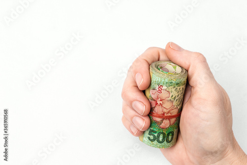 Argentine peso banknotes held by female hand 