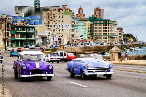 HAVANA, CUBA - NOVEMBER 15, 2017: Old classic vintage cars drive in traffic along famous Malecon avenue in central Havana - the capital of Cuba. © Milosz Maslanka