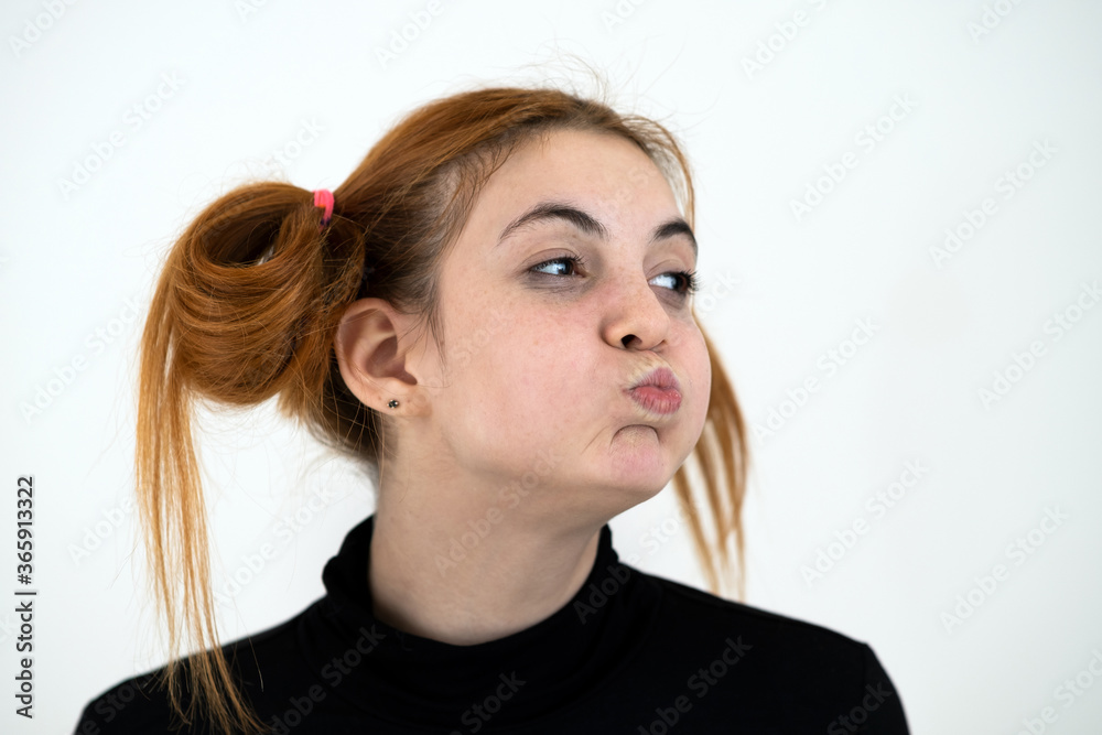 Closeup portrait of a funny redhead teenage girl with childish hairstyle isolated on white backround. Closeup portrait of a funny redhead teenage girl with childish hairstyle isolated on white backround.