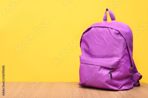 School backpack on a yellow background. Place for text