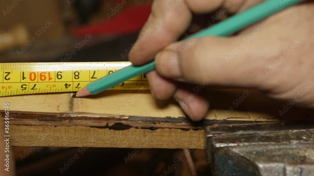 Carpenter using tape measure and pencil on wood slow motion Carpenter using tape measure and pencil on wood slow motion