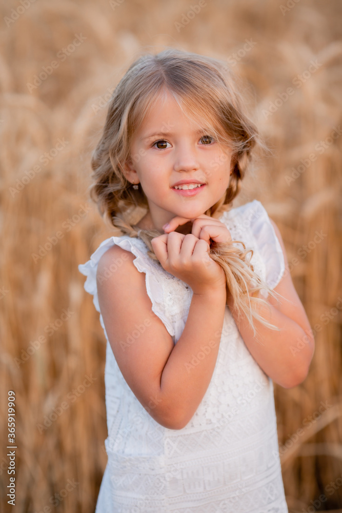 Little blonde girl walks in a summer wheat field Little blonde girl walks in a summer wheat field
