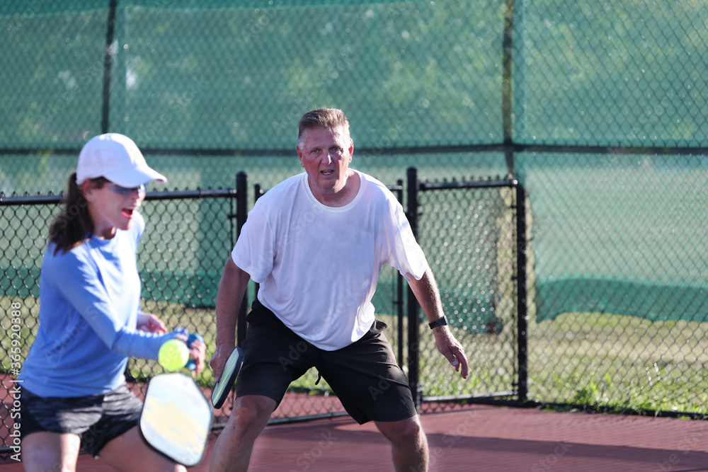 Fotografie A mixed doubles team competes in a pickleball match