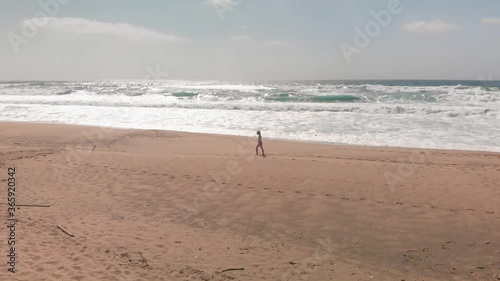 Ragazza cammina sulla spiaggia