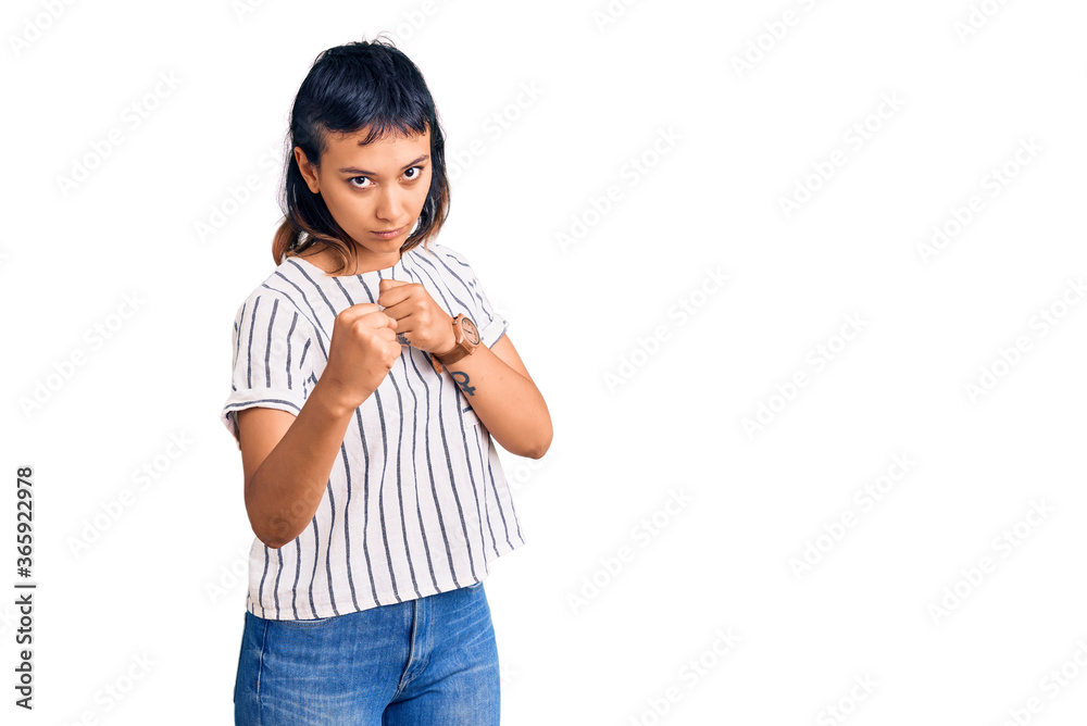 Young woman wearing casual clothes ready to fight with fist defense gesture, angry and upset face, afraid of problem Young woman wearing casual clothes ready to fight with fist defense gesture, angry and upset face, afraid of problem