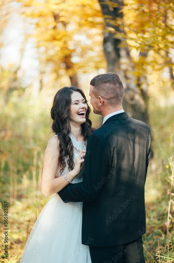 Groom hugging his laughing bride in green park. Wedding. Groom hugging his laughing bride in green park. Wedding.