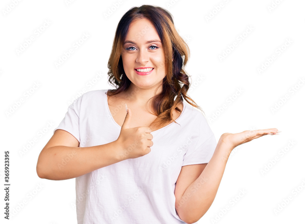 Young beautiful caucasian woman wearing casual white tshirt showing palm hand and doing ok gesture with thumbs up, smiling happy and cheerful Young beautiful caucasian woman wearing casual white tshirt showing palm hand and doing ok gesture with thumbs up, smiling happy and cheerful