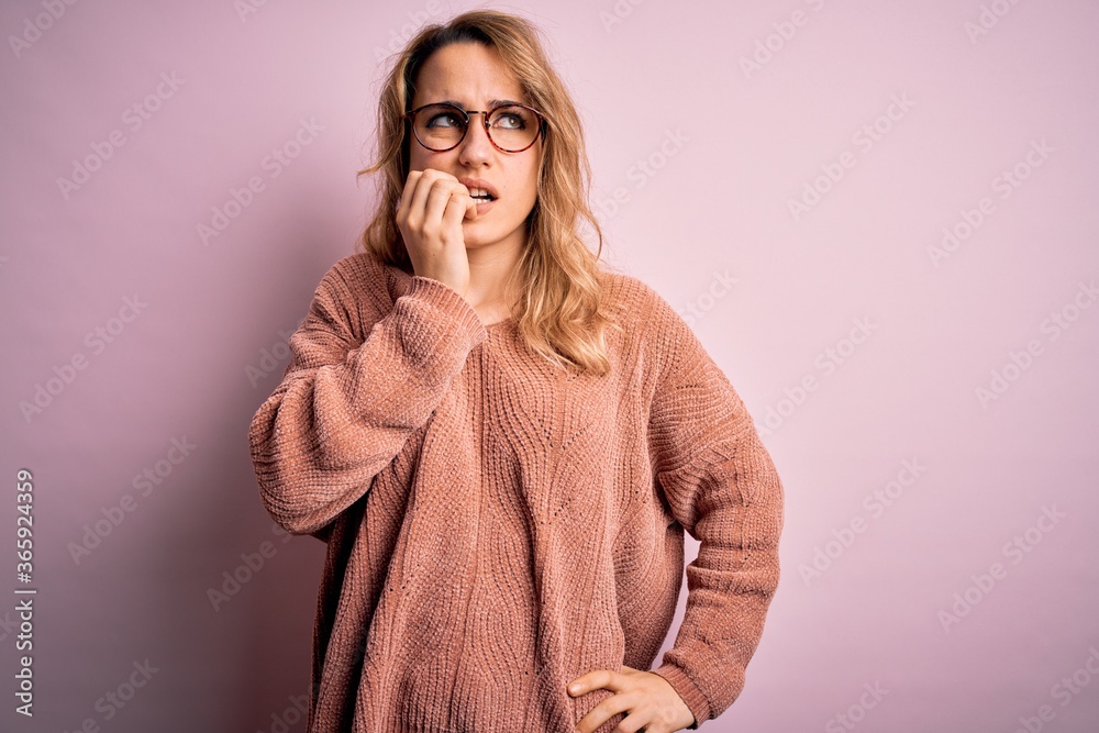 Young beautiful blonde woman wearing casual sweater and glasses over pink background looking stressed and nervous with hands on mouth biting nails. Anxiety problem. Young beautiful blonde woman wearing casual sweater and glasses over pink background looking stressed and nervous with hands on mouth biting nails. Anxiety problem.