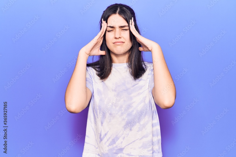 Young beautiful girl wearing casual t shirt with hand on head, headache because stress. suffering migraine. Young beautiful girl wearing casual t shirt with hand on head, headache because stress. suffering migraine.