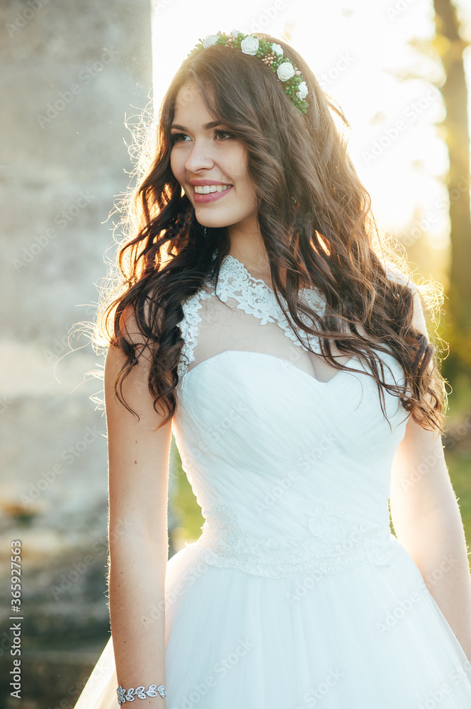 Happy beautiful young bride outside on a summer meadow at the sunset Happy beautiful young bride outside on a summer meadow at the sunset