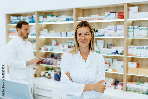 Male and female pharmacists working together at modern pharmacy.