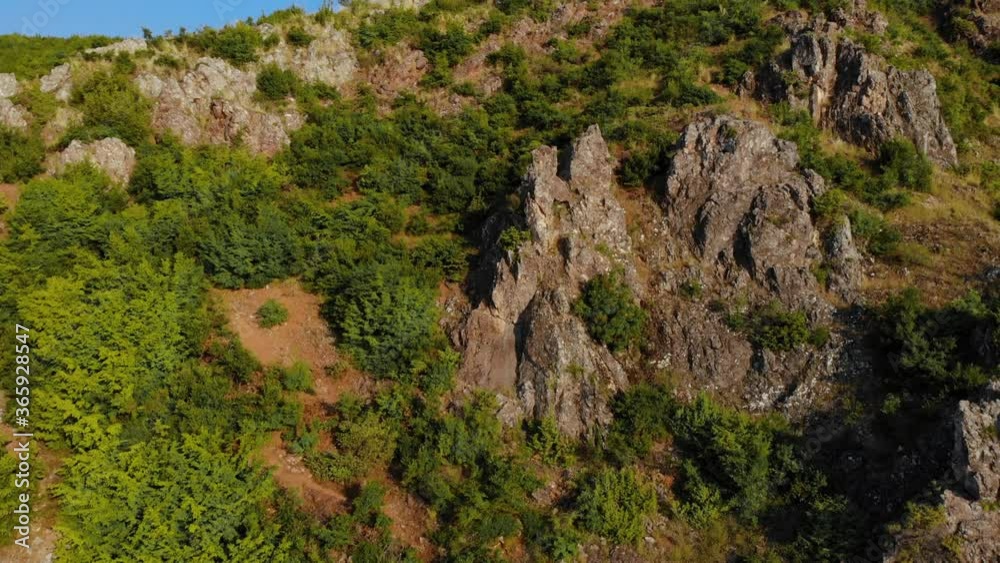 Rocky mountain with cliffs surrounded by green vegetation on a summer sunny day Rocky mountain with cliffs surrounded by green vegetation on a summer sunny day