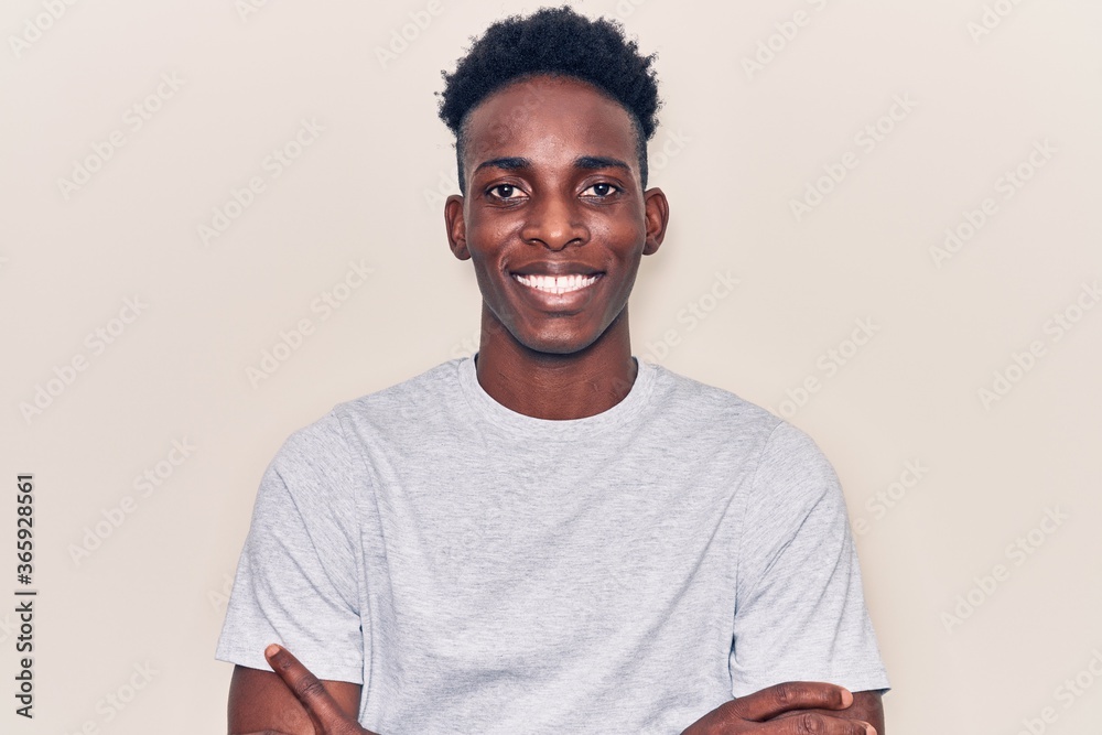Young african american man wearing casual clothes happy face smiling with crossed arms looking at the camera. positive person. Young african american man wearing casual clothes happy face smiling with crossed arms looking at the camera. positive person.