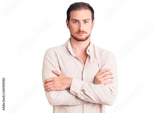 Young handsome caucasian man wearing casual clothes skeptic and nervous, disapproving expression on face with crossed arms. negative person.