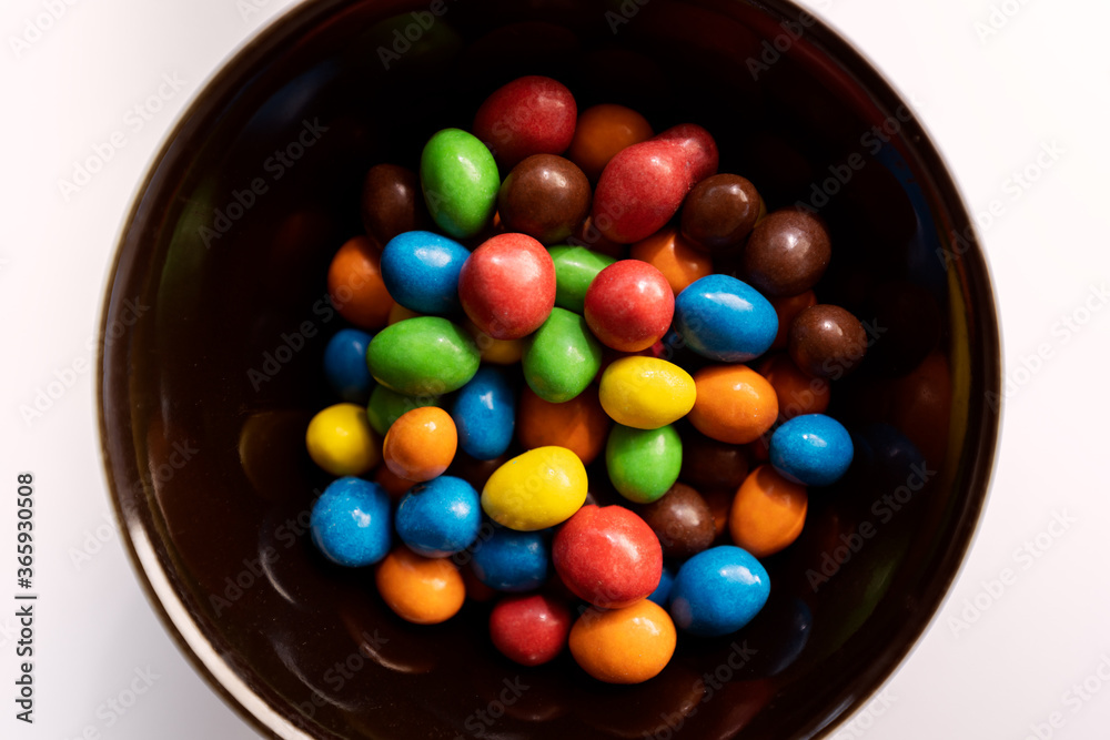 Colorful candies on black bowl