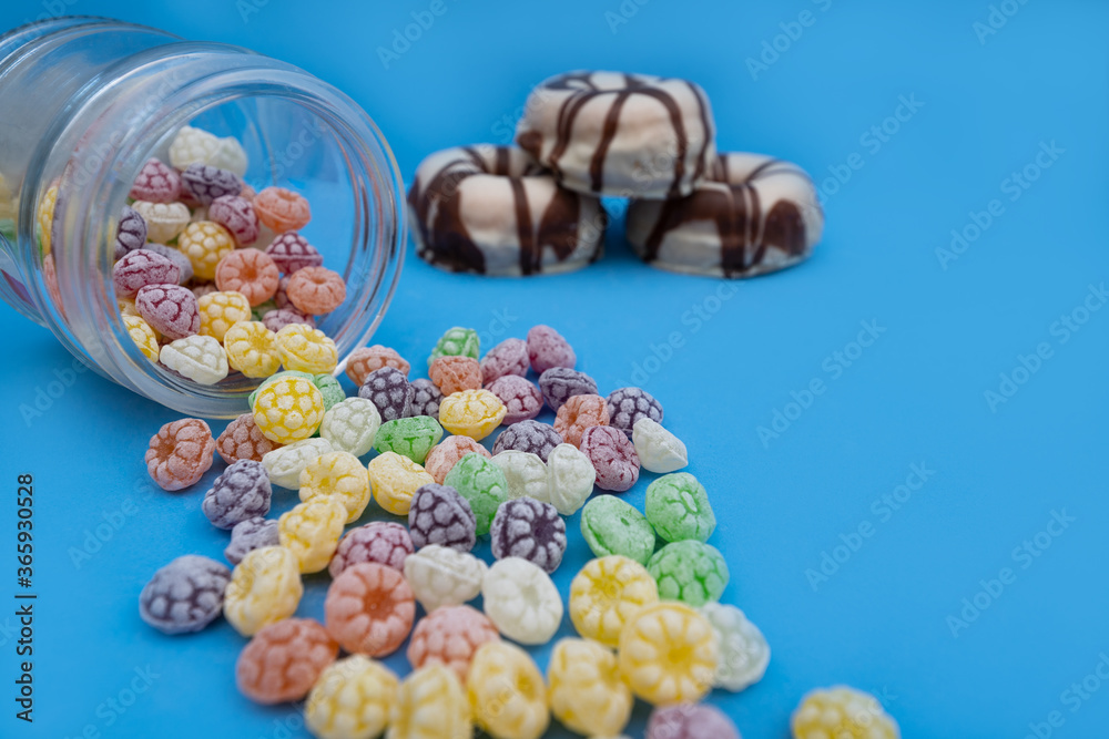 Donuts and colorful candies on blue background