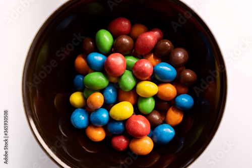 Colorful candies on black bowl