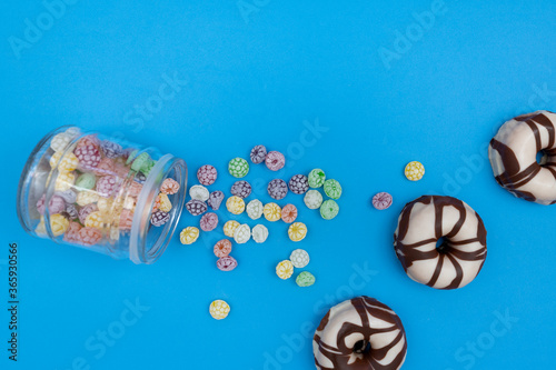 Donuts and colorful candies on blue background
