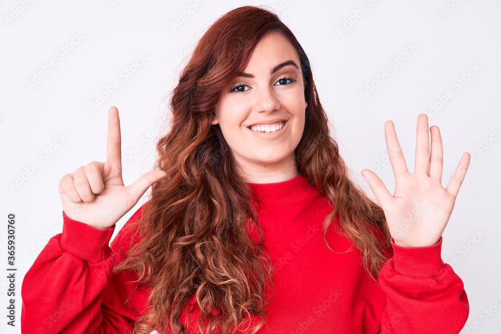 Young beautiful woman wearing casual clothes showing and pointing up with fingers number seven while smiling confident and happy. Young beautiful woman wearing casual clothes showing and pointing up with fingers number seven while smiling confident and happy.