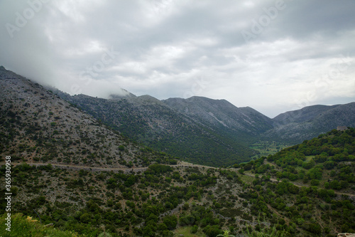 Nature of the island of Crete in Greece. Panorama with a view of the mountains and mountain path, against a cloudy sky with clouds