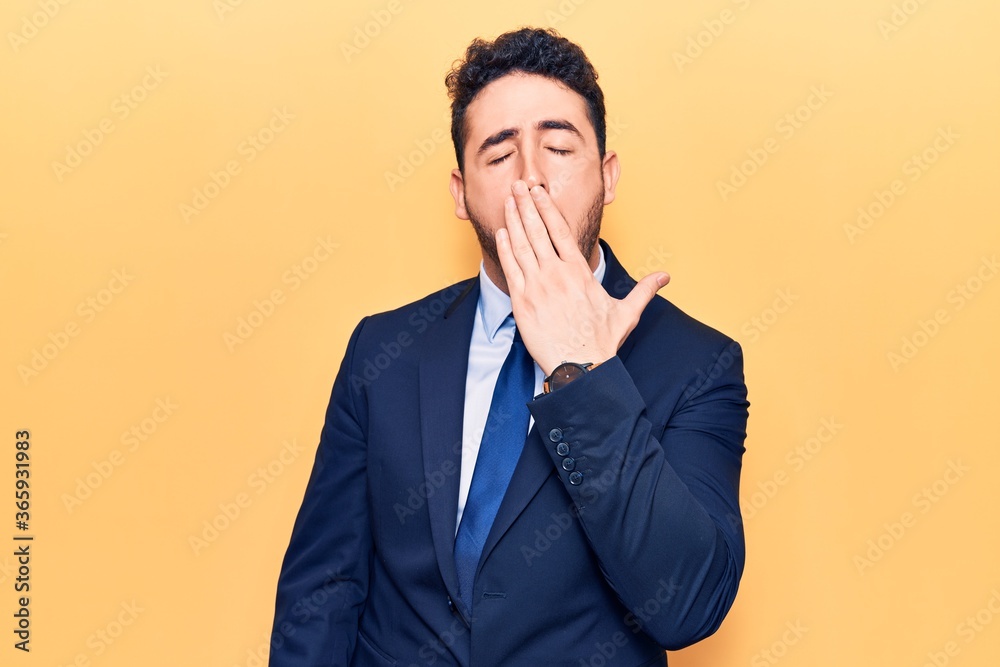 Young hispanic man wearing suit bored yawning tired covering mouth with hand. restless and sleepiness. Young hispanic man wearing suit bored yawning tired covering mouth with hand. restless and sleepiness.