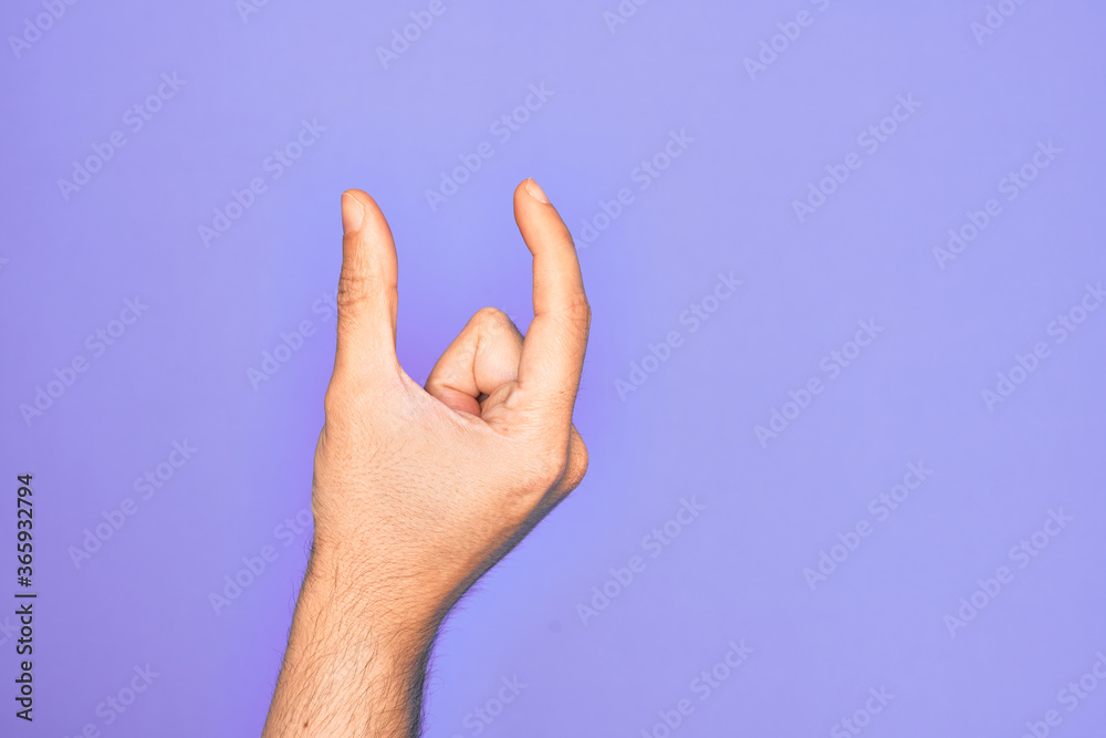 Hand of caucasian young man showing fingers over isolated purple background picking and taking invisible thing, holding object with fingers showing space Hand of caucasian young man showing fingers over isolated purple background picking and taking invisible thing, holding object with fingers showing space