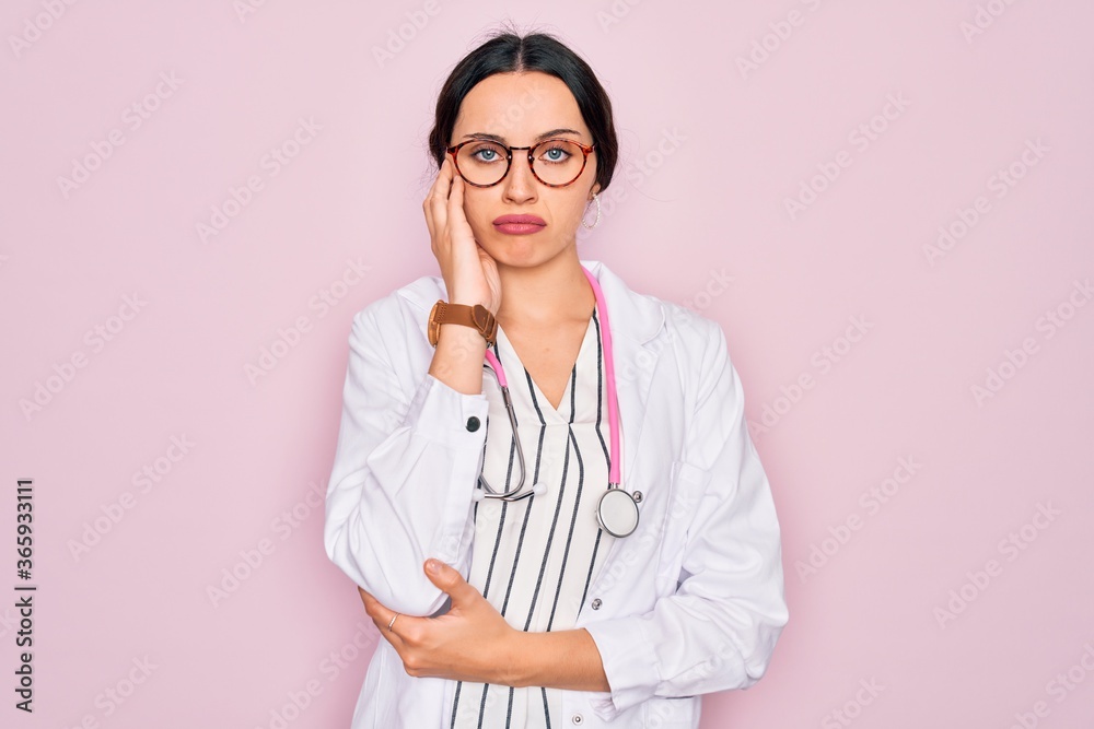 Beautiful doctor woman with blue eyes wearing coat and stethoscope over pink background thinking looking tired and bored with depression problems with crossed arms. Beautiful doctor woman with blue eyes wearing coat and stethoscope over pink background thinking looking tired and bored with depression problems with crossed arms.