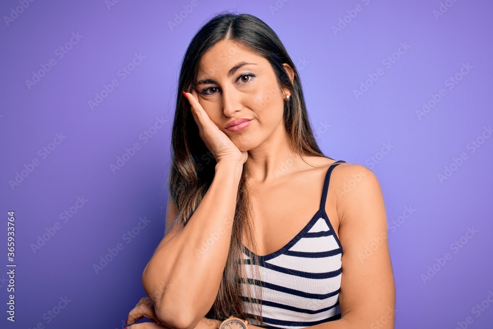 Young beautiful woman wearing casual summer striped top over purple isolated background thinking looking tired and bored with depression problems with crossed arms. Young beautiful woman wearing casual summer striped top over purple isolated background thinking looking tired and bored with depression problems with crossed arms.