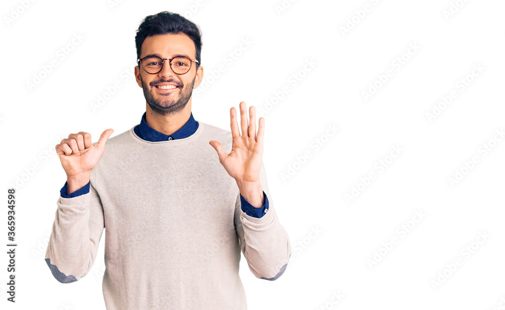 Young handsome hispanic man wearing elegant clothes and glasses showing and pointing up with fingers number six while smiling confident and happy. Young handsome hispanic man wearing elegant clothes and glasses showing and pointing up with fingers number six while smiling confident and happy.