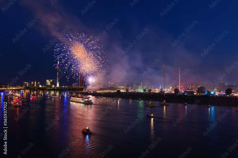 Outdoor night scenery of firework over Rhein River in Düsseldorf during Rheinkirmes Festival in Summer season.
