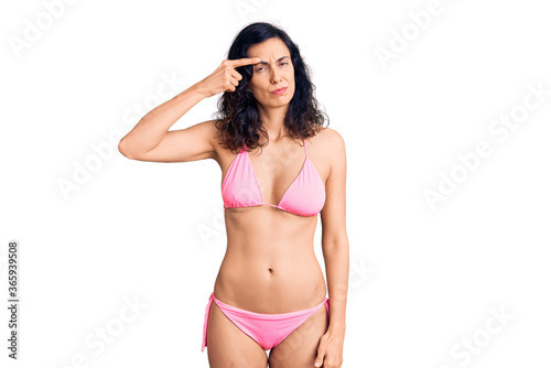 Young beautiful hispanic woman wearing bikini pointing unhappy to pimple on forehead, ugly infection of blackhead. acne and skin problem © Krakenimages.com