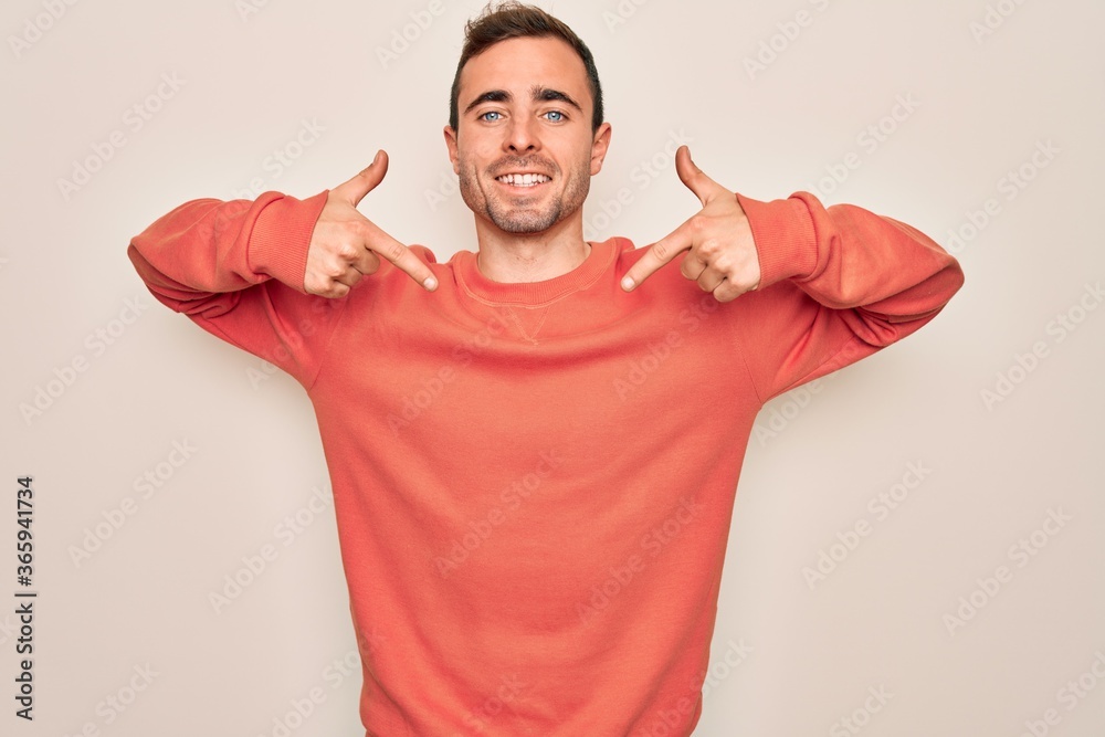 Young handsome man with blue eyes wearing casual sweater standing over white background looking confident with smile on face, pointing oneself with fingers proud and happy. Young handsome man with blue eyes wearing casual sweater standing over white background looking confident with smile on face, pointing oneself with fingers proud and happy.