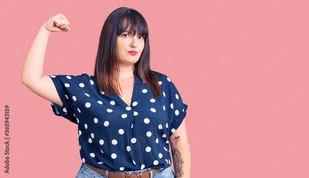 Young plus size woman wearing casual clothes strong person showing arm muscle, confident and proud of power Young plus size woman wearing casual clothes strong person showing arm muscle, confident and proud of power