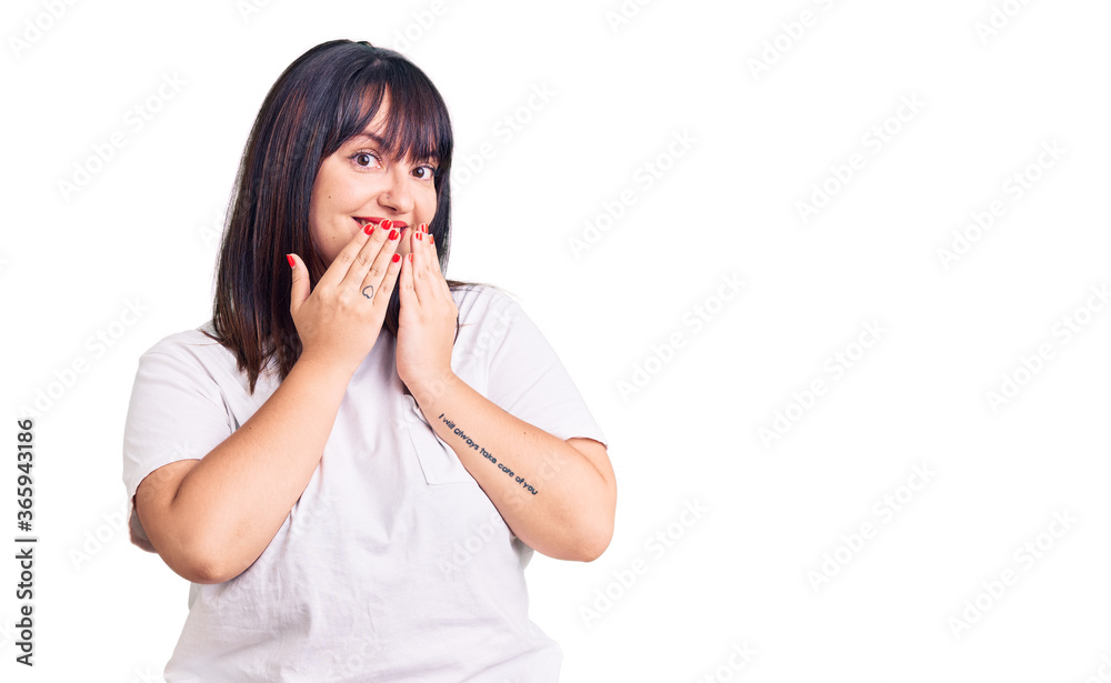 Young plus size woman wearing casual clothes laughing and embarrassed giggle covering mouth with hands, gossip and scandal concept