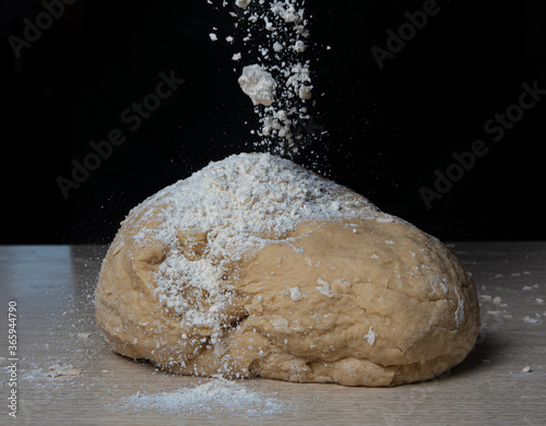 homemade dough with flour on wooden table, selective focus.