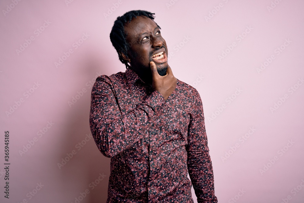 Young handsome african american man wearing casual shirt standing over pink background Thinking worried about a question, concerned and nervous with hand on chin Young handsome african american man wearing casual shirt standing over pink background Thinking worried about a question, concerned and nervous with hand on chin