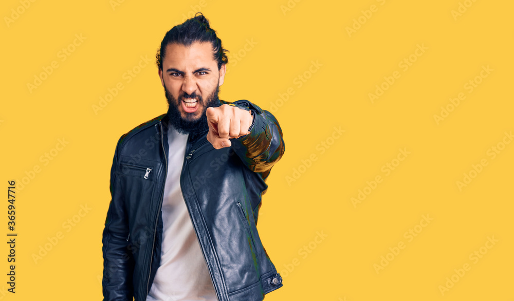 Young arab man wearing casual leather jacket pointing displeased and frustrated to the camera, angry and furious with you Young arab man wearing casual leather jacket pointing displeased and frustrated to the camera, angry and furious with you