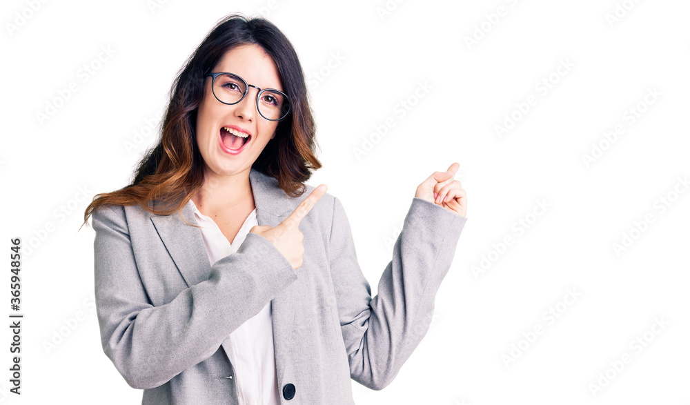 Beautiful young brunette woman wearing business clothes and glasses smiling and looking at the camera pointing with two hands and fingers to the side. Beautiful young brunette woman wearing business clothes and glasses smiling and looking at the camera pointing with two hands and fingers to the side.