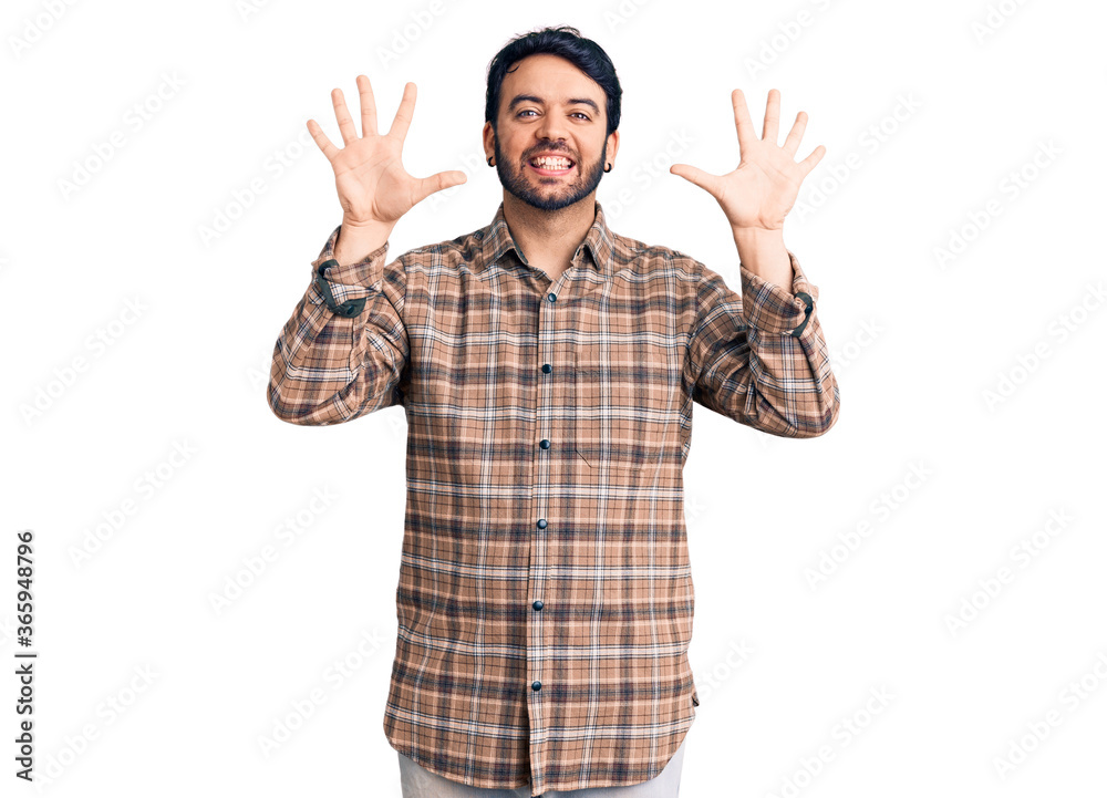 Young hispanic man wearing casual clothes showing and pointing up with fingers number ten while smiling confident and happy. Young hispanic man wearing casual clothes showing and pointing up with fingers number ten while smiling confident and happy.