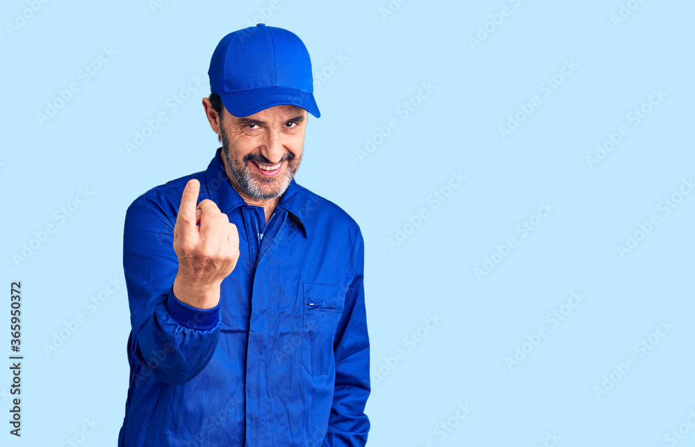 Middle age handsome man wearing mechanic uniform beckoning come here gesture with hand inviting welcoming happy and smiling Middle age handsome man wearing mechanic uniform beckoning come here gesture with hand inviting welcoming happy and smiling